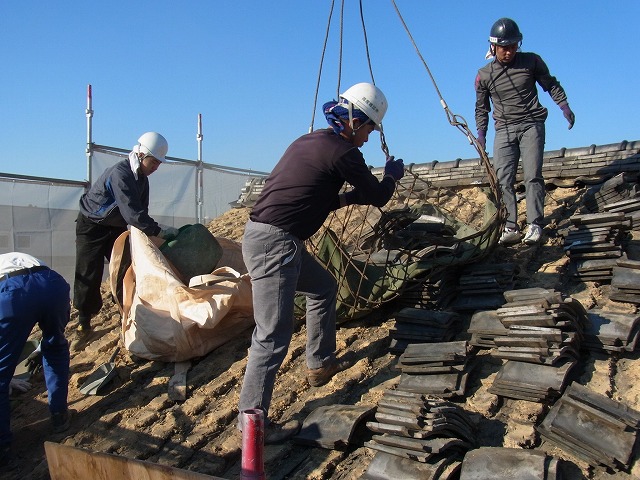 古い瓦をクレーンのネットに入れる